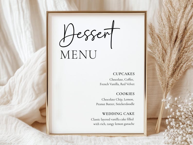 May include: A framed dessert menu with the word "Dessert" in elegant script above "MENU". The menu lists cupcake flavors like chocolate and red velvet, cookie flavors like chocolate chip and snickerdoodle, and a wedding cake description.