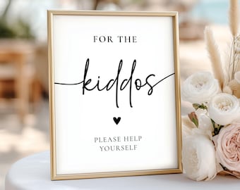 May include: A framed sign with gold trim and white background. The sign reads "FOR THE kiddos" in a stylish script font, with a small black heart below. The text "PLEASE HELP YOURSELF" is at the bottom.