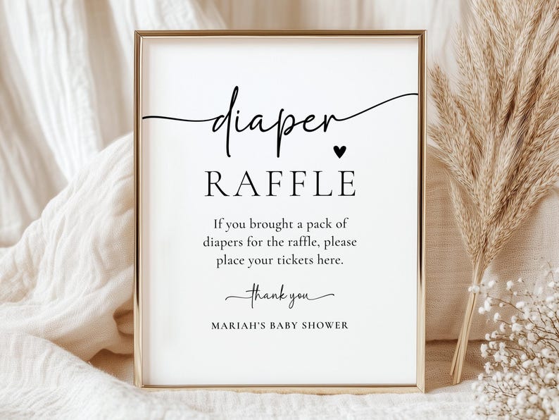 Może przedstawiać: Oprawiony znak z napisem "diaper RAFFLE" czarnym skryptem. Znak zawiera instrukcje dotyczące loterii na baby shower oraz tekst "thank you" i "MARIAH'S BABY SHOWER". Rama jest złota.