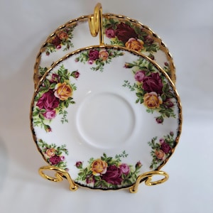 Puede incluir: Juego de platos de dos niveles con asa y soporte dorados. Los platos blancos están decorados con un estampado floral de rosas amarillas, rosas y burdeos con hojas verdes. Los bordes están ribeteados en dorado.