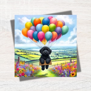 May include: A black dog wearing a harness is floating in the air, holding onto a bunch of colourful balloons. The dog is looking at the camera. The balloons are against a blue sky with white clouds. The dog is floating over a green field with flowers.