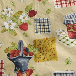 May include: A beige fabric with a repeating pattern of strawberries, daisies, and jam jars. The design includes patches of plaid and floral patterns. A basket of strawberries is also featured in the design.