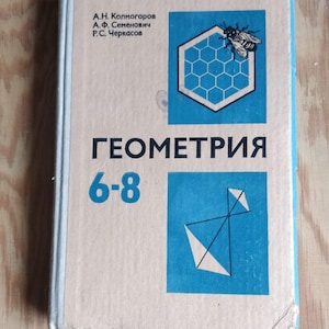 Può includere: Un libro color beige con una copertina blu. La copertina ha il titolo "GEOMETRIA 6-8" in testo nero. Il libro è di A.N. Kolmogorov, A.F. Semenovich e P.C. Cherasov. C'è un'ape su un favo di miele nella parte superiore sinistra della copertina e una forma geometrica nella parte inferiore destra.