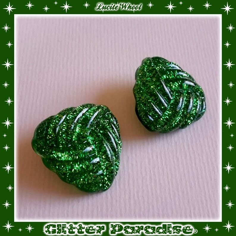 May include: Two green glitter heart-shaped buttons. The buttons have a woven design and are made of glass.