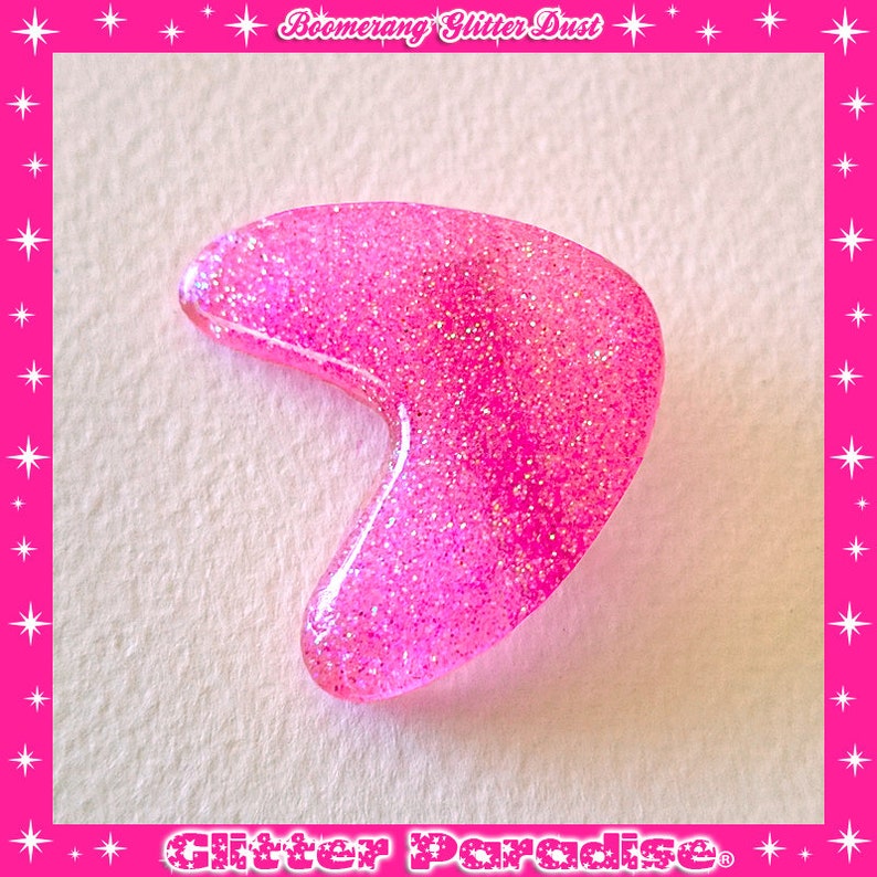 May include: Pink glitter boomerang charm. The charm is made of resin and has a shiny, sparkly finish.