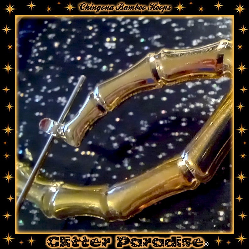 K&ouml;nnte beinhalten: Ein goldfarbener Creolen-Ohrring mit strukturiertem Bambus-Design. Der Ohrring verf&uuml;gt &uuml;ber einen klappbaren Stiftverschluss. Das Bild enth&auml;lt den Text Chingona Bamboo Hoops oben und Glitter Paradise unten vor einem dunklen Hintergrund.