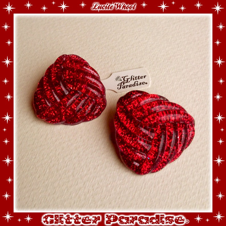 May include: A pair of red, sparkly, lucite earrings in a knotted design. The earrings are labeled "Glitter Paradise".