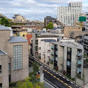 May include: An aerial view of a city with a mix of modern and traditional buildings. The buildings are mostly concrete and brick, with some having wooden accents. The buildings are clustered together, creating a dense urban environment.