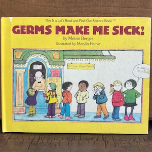 May include: A yellow children's book titled "GERMS MAKE ME SICK!" by Melvin Berger. The cover illustration depicts a line of children outside a building, with one child sneezing. Text includes "SPECIAL SHOW TODAY" and "HE SHOULD STAY HOME".