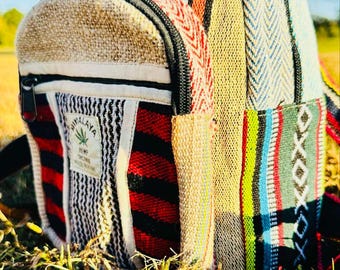 May include: A small, multi-coloured hemp backpack with a zipper closure and a "Himalaya Hemp Textile" label. The backpack is made of woven fabric with a variety of colours and patterns, including red, blue, green, yellow, and white.