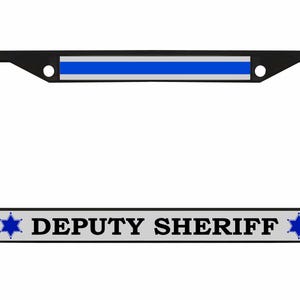 May include: Black license plate frame with a blue stripe at the top and the words "DEPUTY SHERIFF" in bold, gray letters. Blue star emblems flank the text. The frame is designed to fit a standard U.S. license plate.