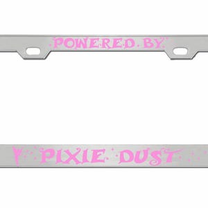 May include: Silver license plate frame with the text "POWERED BY PIXIE DUST" in pink lettering.