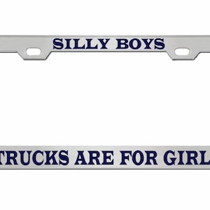 May include: A silver license plate frame with the text "Silly Boys Trucks Are For Girls" in blue lettering.
