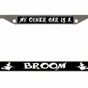 Puede incluir: Un marco de matrícula plateado con el texto "MY OTHER CAR IS A. BROOM" en letras blancas sobre fondos rectangulares negros. Siluetas de brujas en escobas están en cada extremo del texto inferior.