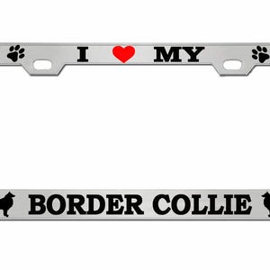 May include: A silver license plate frame with the text "I ❤️ MY BORDER COLLIE" in black. The heart is red. The frame has paw prints and dog bone designs. Silhouettes of Border Collies are on each side.