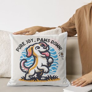 Peut inclure: Un coussin blanc avec une illustration de dessin animé d'un chien avec le texte "PURE JOY, PAWS DOWN!"