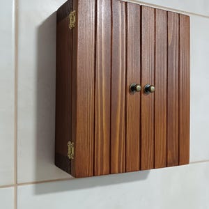 Wall mounted solid wood bathroom cabinet with marine plywood doors and interior shelves for toiletries in modern farmhouse bathroom