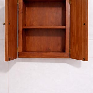 Wall mounted solid wood bathroom cabinet with marine plywood doors and interior shelves for toiletries in modern farmhouse bathroom