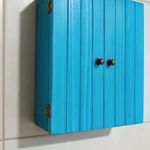 Wall mounted solid wood bathroom cabinet with marine plywood doors and interior shelves for toiletries in modern farmhouse bathroom