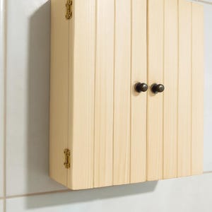 Wall mounted solid wood bathroom cabinet with marine plywood doors and interior shelves for toiletries in modern farmhouse bathroom