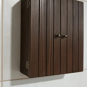 Wall mounted solid wood bathroom cabinet with marine plywood doors and interior shelves for toiletries in modern farmhouse bathroom