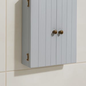 Wall mounted solid wood bathroom cabinet with marine plywood doors and interior shelves for toiletries in modern farmhouse bathroom