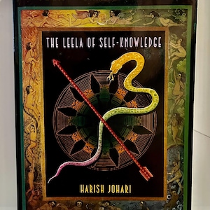 May include: A book titled "The Yoga of Snakes and Arrows" with the subtitle "The Leela of Self-Knowledge" by Harish Johari. The cover features a yellow and green snake, a red arrow, and a wheel design on a black background. Includes a full-color foldout game board.