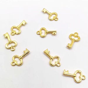 15 key charms, 8 x 15 mm, gold-plated metal