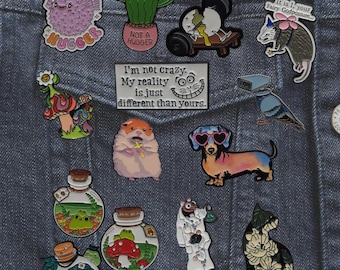 Pines de esmalte con animales divertidos y estilo cottagecore: un tarro de rana peculiar, un cactus que no abraza, un perro salchicha, una zarigüeya, un hongo y un científico de ratas.