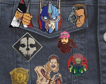 Pines esmaltados inspirados en ciencia ficción y terror: Optimus Prime, Terminator T-800, La Naranja Mecánica, Mars Attacks, La Cosa, El Mandaloriano, COD Ghost