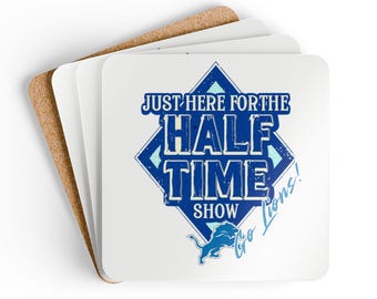 Può includere: Un sottobicchiere quadrato bianco con un rombo blu che contiene il testo "Just here for the Half Time Show Go Lions!" in bianco. Un leone blu mascotte è nell'angolo inferiore.