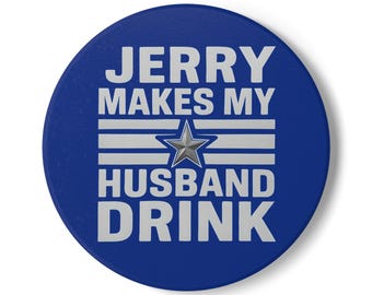 May include: A circular, blue button featuring the text "JERRY MAKES MY HUSBAND DRINK" in white. A silver star is set within a striped design. The button has a solid, dark blue background.