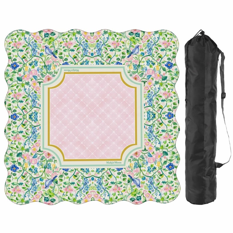May include: A square scalloped-edge mat featuring a floral pattern with blue birds, pink flowers, and green vines surrounding a central pink diamond-patterned panel with gold and light green borders, accompanied by a black cylindrical carrying bag.