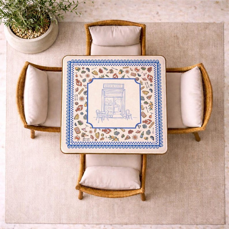 Puede incluir: Una mesa de comedor cuadrada con superficie blanca, borde azul y una ilustraci&oacute;n central de la fachada de un restaurante con la palabra RISTORANTE, rodeada de peque&ntilde;os iconos coloridos de comida y bebida, junto a cuatro sillas de mimbre.