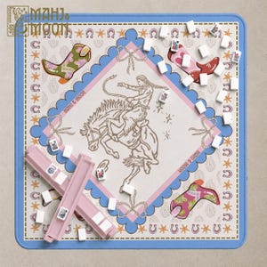 Peut inclure: Un tapis de mah-jong carré Mahj & Moon avec une illustration centrale d'une personne montant un cheval au galop, entourée de bordures festonnées roses et bleues, de bottes de cow-boy, de fers à cheval et de tuiles de mah-jong blanches.