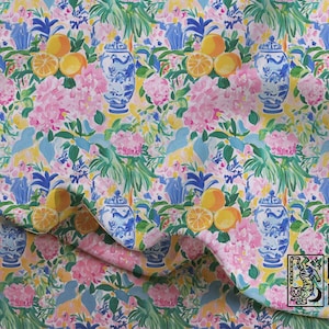 May include: Fabric featuring a repeating pattern of blue and white ginger jars, yellow citrus fruits, and pink floral clusters on a light yellow background. The bottom right corner displays a logo with the text MAHJ & MOON and a tiger illustration.
