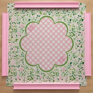 Peut inclure: Surface à motif vichy rose et blanc avec une bordure verte festonnée, entourée d'un motif floral. Les coins ont des rails roses. Le texte "MAHI MOON" est imprimé sur la surface.