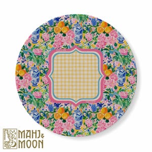 May include: A round decorative plate featuring a vibrant pattern of blue and white ginger jars, pink flowers, and orange citrus fruits. In the center, a scalloped-edge frame contains a yellow and white gingham check pattern with a light blue border.