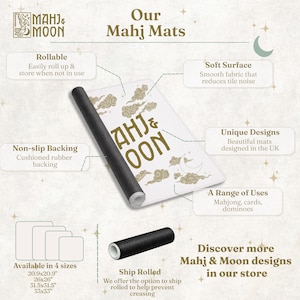 May include: A white Mahj & Moon game mat with gold cloud and moon graphics, featuring a black non-slip rubber backing. The mat is rollable and shown in a partially rolled state. Text includes "Our Mahj Mats" and "Mahj & Moon" with size options listed as 20.9x20.9, 26x26, 31.5x31.5, and 33x33 inches.
