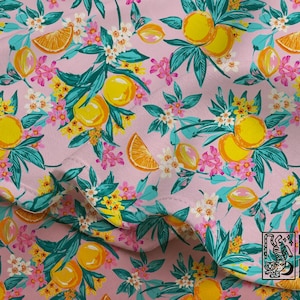 May include: A fabric with a repeating pattern of yellow lemons, orange slices, and white and pink flowers on a light pink background. The leaves are teal and the design is from MAHI & MOON.