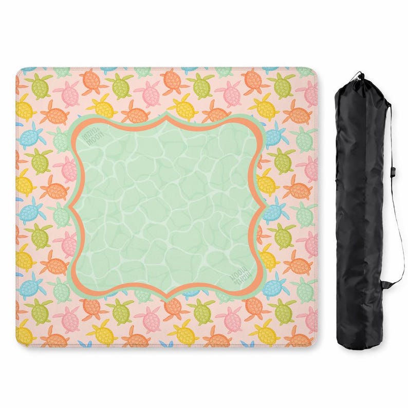 May include: A square mat featuring a repeating pattern of small turtles in shades of pink, orange, yellow, blue, and green on a light background. A central light green scalloped frame with an orange border contains the text "MAIN MOON". A black carrying bag is included.