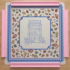 Puede incluir: Un tablero de rompecabezas cuadrado con una superficie clara que presenta una ilustraci&oacute;n central de una fachada de restaurante con la etiqueta RISTORANTE, rodeada por un patr&oacute;n de iconos de comida y vida marina, enmarcado por un borde azul y bordes de pl&aacute;stico rosa.