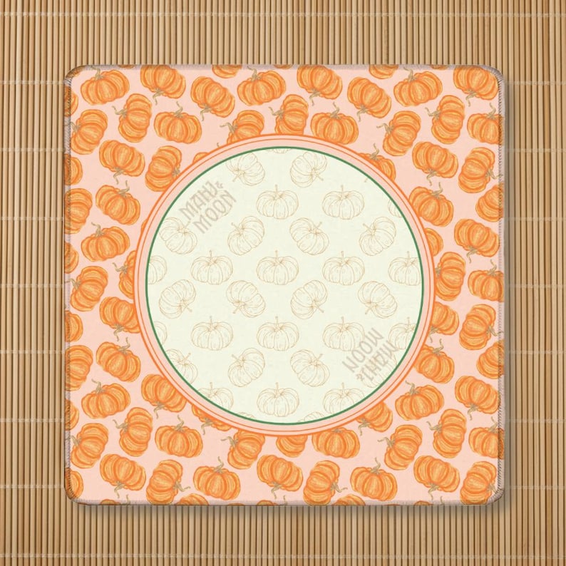 May include: Square mousepad with a pumpkin pattern on a light pink background. The pumpkins are orange with green stems. A central circle features a pumpkin design and the text "MAHJ & MOON".