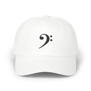 Puede incluir: Gorra de béisbol blanca con un símbolo de clave de sol negro. La gorra tiene una visera curva y una corona estructurada. El diseño es simple y limpio, adecuado para los amantes de la música.