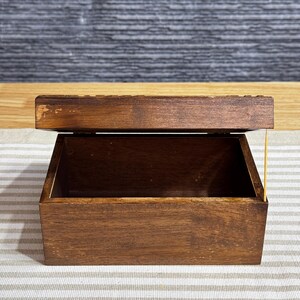 May include: A dark brown wooden box with a hinged lid. The box is empty and the lid is open.