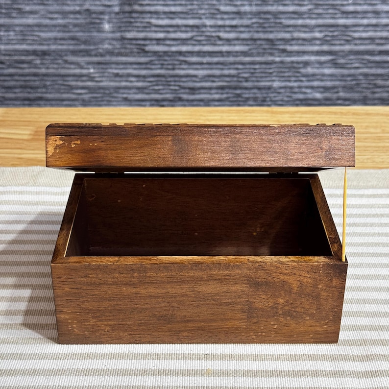 May include: A dark brown wooden box with a hinged lid. The box is empty and the lid is open.