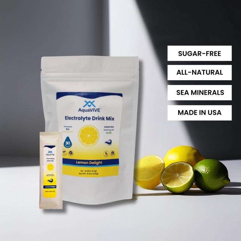 May include: A white pouch with a yellow lemon design and the text "AquaVIVE Electrolyte Drink Mix Lemon Delight" on the front. The pouch is labeled "Sugar-Free, All-Natural, Sea Minerals, Made in USA".