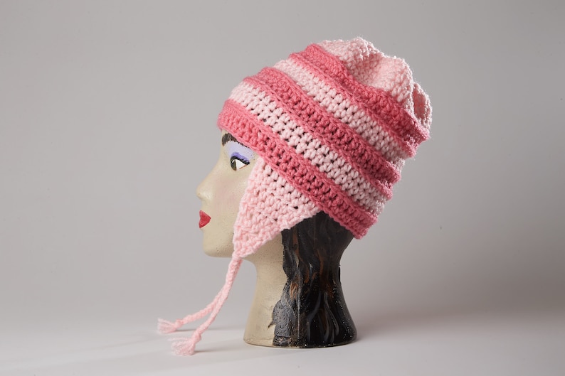 May include: Pink and light pink striped crocheted hat with ear flaps and a long tie.