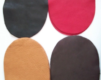 May include: Four leather patches in different colors: black, red, brown, and dark brown. The patches are oval shaped and have a textured surface.