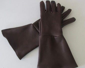 May include: A pair of brown leather gloves with long cuffs. The gloves have a textured surface and are designed to cover the entire hand and wrist.